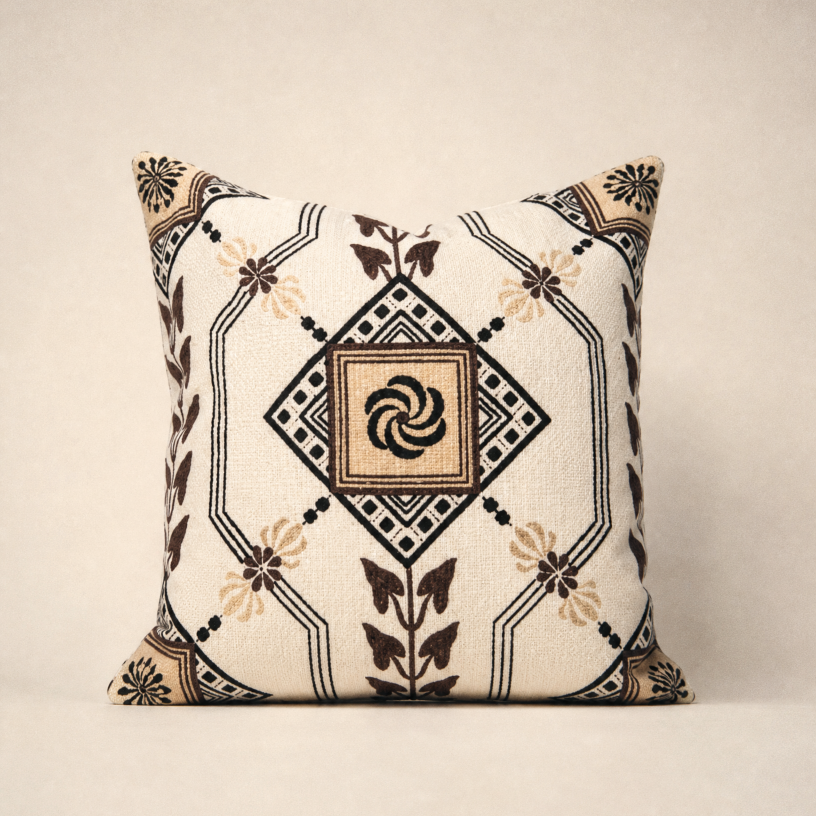 A square throw pillow with a bohemian-style geometric and floral pattern in beige, black, and brown on a cream background, set against a neutral beige backdrop.